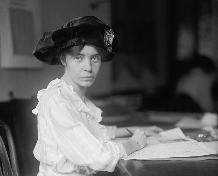 Alice Paul sitting at a desk.